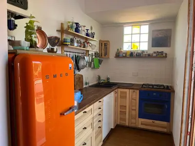 a kitchen with an orange refrigerator in a room at San Saba Rooftop Garden in Rome