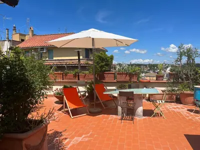 a patio with an umbrella and a table and chairs at San Saba Rooftop Garden in Rome