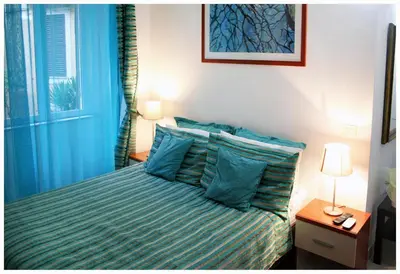 a blue bedroom with a bed with blue pillows at 1A Grace House in Rome
