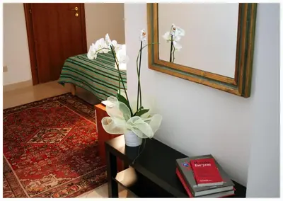 a vase with white flowers on a table in a room at 1A Grace House in Rome