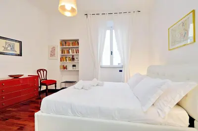 a white bedroom with a white bed and a red dresser at RomeAsYouLike-Monti Experience 295 in Rome
