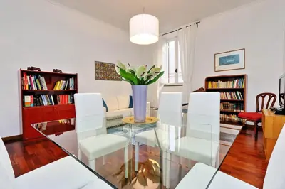 a dining room with a glass table and white chairs at RomeAsYouLike-Monti Experience 295 in Rome