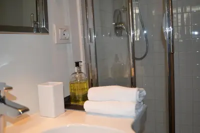 a bathroom with a shower and a sink with towels at Banchi Vecchi NY in Rome