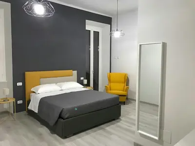 a bedroom with a bed and a yellow chair at Sensation House in Rome