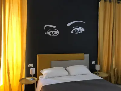 a bedroom with a bed with eyes on the wall at Sensation House in Rome