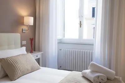 a bedroom with a white bed and a window at Le Stanze Di Gaia in Rome