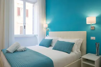 a blue bedroom with a bed with two pillows at Le Stanze Di Gaia in Rome