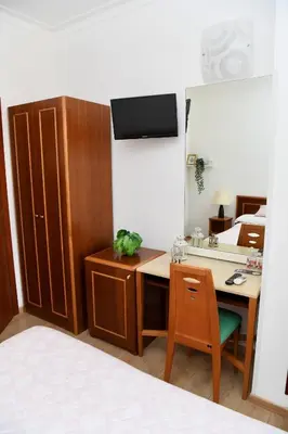 a room with a desk and a mirror and a bed at Hotel Anacapri in Rome