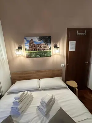 a bedroom with a bed with two towels on it at Vatican QG Rooms in Rome