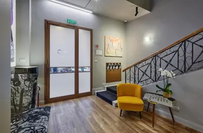 a living room with a staircase and a yellow chair at L'obelisque maison de luxe in Rome