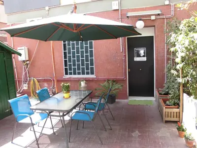 a patio with a table and chairs and an umbrella at Mikasa Piazza Bologna in Rome