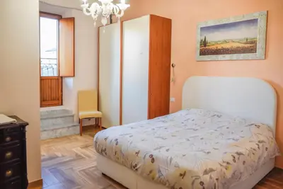 a bedroom with a bed and a cabinet and a window at Penthouse Angelo Brunetti in Rome