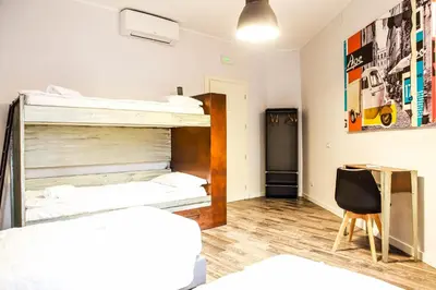 a room with two bunk beds and a desk at Hostel Trastevere in Rome