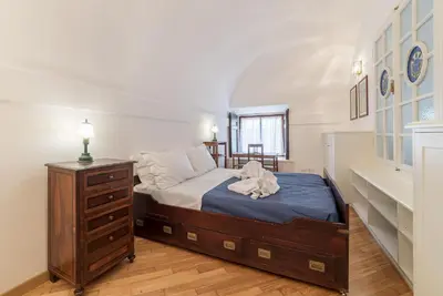 a bedroom with a bed and a dresser in a room at Campitelli Fascinating Apartment in Rome