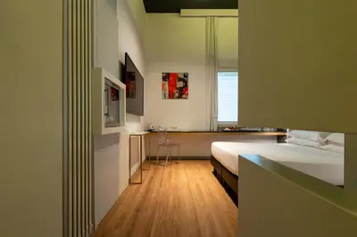 a bedroom with a bed and a desk and a window at Maison Pellegrino in Rome