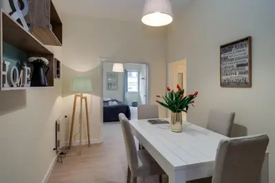 a dining room and living room with a white table and chairs at Romefinestay Apartments Sistina in Rome