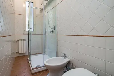 a bathroom with a toilet and a glass shower at Romefinestay Apartments Sistina in Rome