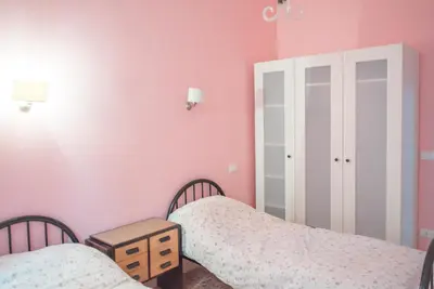 a bedroom with two beds and pink walls at Frattina De Luxe in Rome