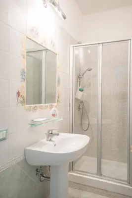 a white bathroom with a sink and a shower at Frattina De Luxe in Rome
