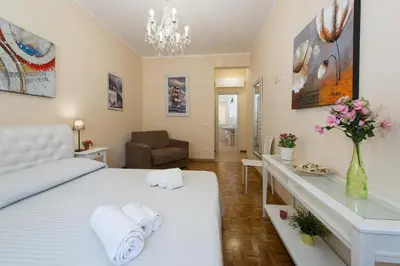 a bedroom with a white bed and a table with towels at Gregory House in Rome