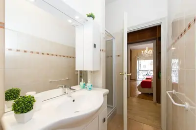 a white bathroom with a sink and a mirror at Gregory House in Rome