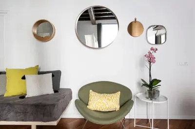 a living room with a chair and a mirror at Apartment Near Trevi Fountain in Rome