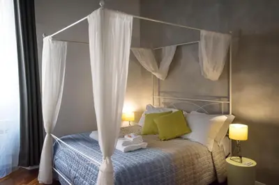 a bedroom with a canopy bed with white curtains at Apartment Near Trevi Fountain in Rome