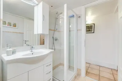 a white bathroom with a sink and a shower at Domus Ricca Termini in Rome