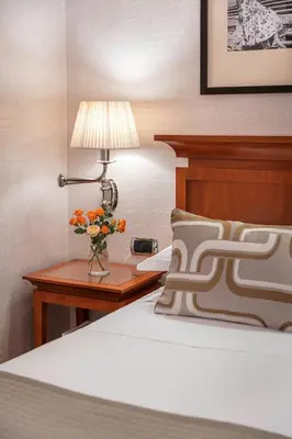 a bedroom with a bed and a table with a lamp at Starhotels Metropole in Rome