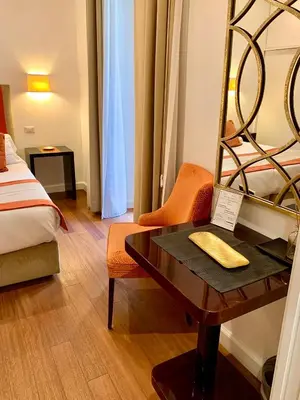 a hotel room with a desk and a bed and a mirror at 900 Piazza del Popolo in Rome
