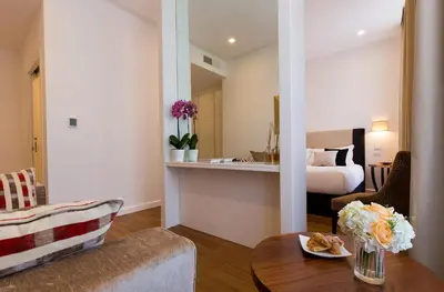 a living room with a table and a room with a bed at 900 Piazza del Popolo in Rome