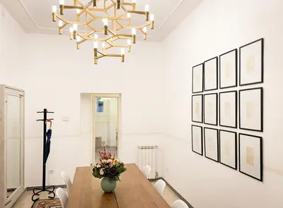 a dining room with a table and a chandelier at Modern Comfort, Poetic Charm in Rome