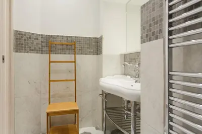 a bathroom with a sink and a mirror at Modern Comfort, Poetic Charm in Rome