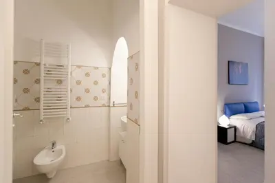 a bathroom with a sink and a toilet and a bed at BoRooms in Rome