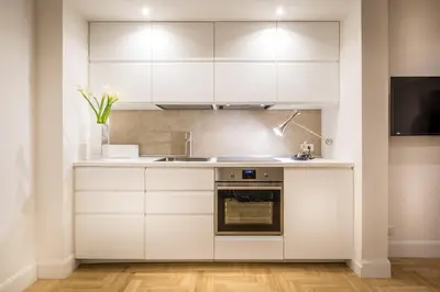 a kitchen with white cabinets and a sink at Old Town Apartments Rome in Rome