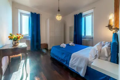 a bedroom with a blue bed and blue curtains at Moma Domus - Golden Keys Collection in Rome