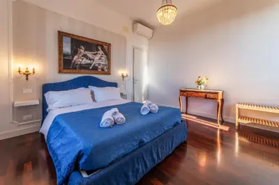 a bedroom with a blue bed with towels on it at Moma Domus - Golden Keys Collection in Rome