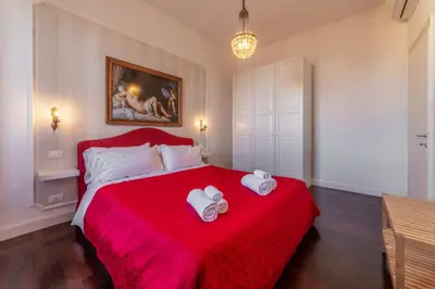 a bedroom with a red bed with two towels on it at Moma Domus - Golden Keys Collection in Rome