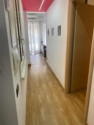 a hallway with a door and a room with wood floors at Casa Vacanze Shivon in Rome