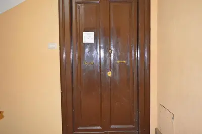 a wooden door in a hallway with papers on it at Oscar Rooms in Rome