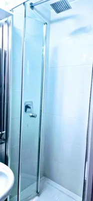 a shower with a glass door next to a sink at Oscar Rooms in Rome