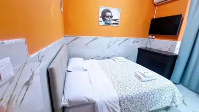 a small room with a bed and a television at Oscar Rooms in Rome
