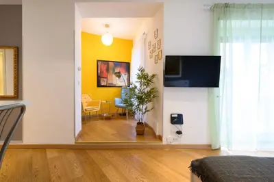 a living room with yellow walls and a dining room at Studio via Nicola Fabrizi in Rome