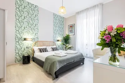 a bedroom with a bed and a vase of flowers at Rome as you feel - Diocleziano Apartment in Rome
