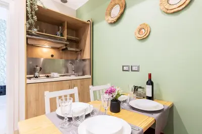 a dining room with a table with a bottle of wine at Rome as you feel - Diocleziano Apartment in Rome