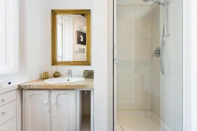 a bathroom with a sink and a shower with a mirror at Andreasuite Trastevere in Rome