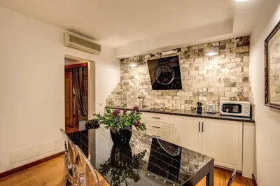 a kitchen with a table with a vase of flowers at Pantheon Miracle Suite in Rome
