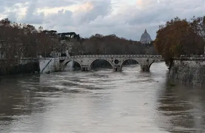a bridge over a river with a view of a city at La Tana di Sofia in Rome