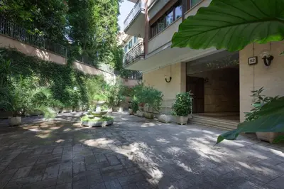 a courtyard of a building with trees and plants at The Apartment Trastevere - Ba.home in Rome