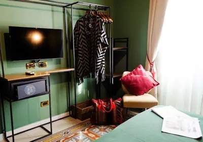 a living room with a television and a room with a chair at Eterna Roma in Rome